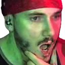 Man with a bandana looking shocked with his mouth wide open and hand on his chin.