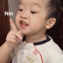 A toddler wagging their index finger in a gesture of disapproval.