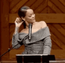 Rihanna flipping her hair with a confident and sassy expression.