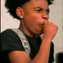 Young man looking off-camera with a skeptical expression while covering his mouth with his hand.