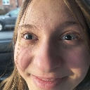 Person with wide eyes and a slight, closed-mouth smile looking directly at the camera.