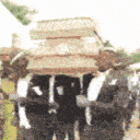 Pallbearers in black suits dancing while carrying a coffin on their shoulders.