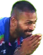 Hardik Pandya smiling with his hands pressed together in a respectful gesture.