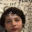 A young boy looking blankly at the camera with a white digital loading icon spinning on his forehead against a background of…
