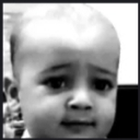 A child with a serious, blank expression staring directly into the camera in black and white.