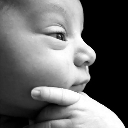Baby resting their chin on their hand with a thoughtful and skeptical expression.
