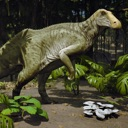 A green dinosaur standing in a forest looking down at a cluster of white mushrooms.