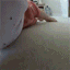 A baby with a neutral expression stares directly into a wide-angle camera lens.