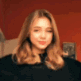 A young woman with brown hair dancing and making various playful facial expressions against a red background.