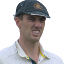 Pat Cummins grimacing with a pained expression while wearing a green cricket cap.