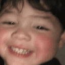 Child with a wide, happy grin and rosy cheeks.