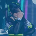 Person covering their face with their hand in a shy or embarrassed gesture.