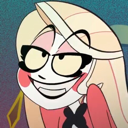 Charlie Morningstar wearing black glasses with a wide, smug, and mischievous grin.