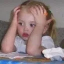 A young child holding their head with both hands while looking off to the side with a confused and overwhelmed expression.