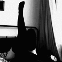 Legs in silhouette kicking upwards against a bright background.
