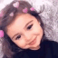A young girl smiling with a pink heart filter overlaying her head.