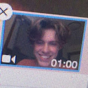 Young man smiling during a video call with a timestamp overlay.