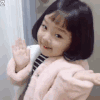 A young girl with a bob haircut blowing a kiss to the camera with a playful expression.