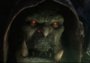 Orc with glowing red eyes and tusks wearing a dark hood.
