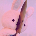A pink stuffed rabbit holds a large kitchen knife in front of its face.
