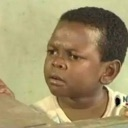 Osita Iheme looking sideways with a suspicious and skeptical facial expression.
