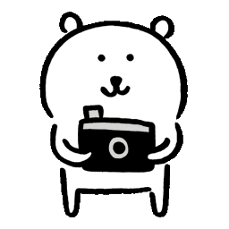 A cute white bear holding a camera and taking photos with a yellow flash.