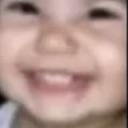 Child with a blurry, wide, and mischievous grin.