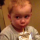 Young child looking sideways with a suspicious expression while holding a drink.