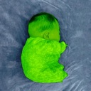 A sleeping baby with neon green skin lying on a blue background.