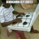 A person sitting and typing on a white kitchen stovetop as if it were a computer keyboard.