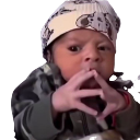 Baby wearing a beanie with a serious expression and fingers pressed together in a plotting gesture.