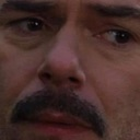 Man with a mustache looking directly at the camera with a concerned and suspicious expression.