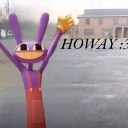 Jax the purple rabbit character waving with both hands in front of a blurry, desolate building background with the text HOWA…