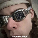 A man wearing glasses constructed from wristwatches looks skeptically at the camera with Russian text below.