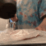 Person slamming a black pan down onto a surface in a quick motion.