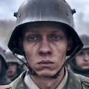 Soldier wearing a steel helmet with a hollow, traumatized thousand-yard stare expression.