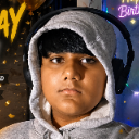 A young boy wearing a gray hoodie and black headphones looking directly at the camera with a neutral expression.