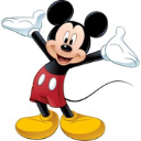 Mickey Mouse standing with his arms wide open and a cheerful smile.