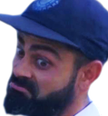 A man with a thick beard and a blue cap looking at the camera with a skeptical and confused expression.