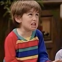 A young boy making a disgusted face with his nose wrinkled and mouth pulled back.