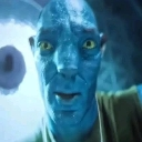 Blue alien character staring intensely with wide yellow eyes and a confused expression.