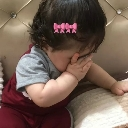 Baby covering their face with their hand in a gesture of embarrassment.