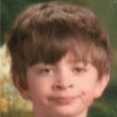 A young boy looking sideways with a skeptical and judgmental facial expression.