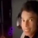 Person wearing headphones with an intense, blurry, and slightly distorted facial expression.