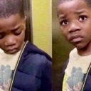 Young boy looking down and then glancing up with a wide-eyed, worried expression.