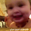 A baby with a wide, open-mouthed laugh and large eyes looking directly into the camera.