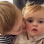 Two toddlers sharing a gentle kiss on the cheek.