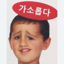 A young boy with a skeptical, unimpressed expression wearing a red oval speech bubble above his head with Korean text.