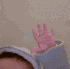 Baby hand waving back and forth in a repetitive motion.