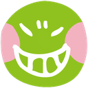 A green round face with a wide, toothy, mischievous grin and pink cheeks.